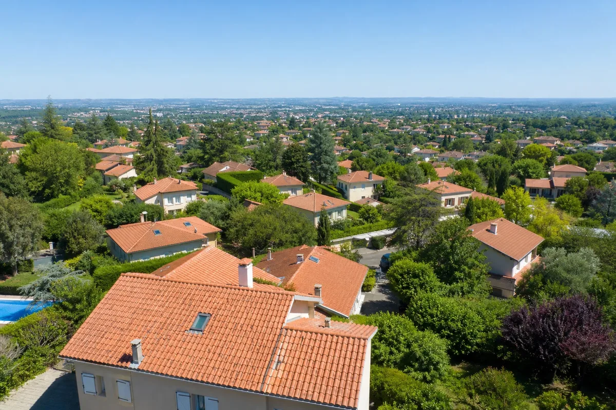 Quartier pavillonnaire français vu de haut, toitures en tuiles aux teintes homogènes