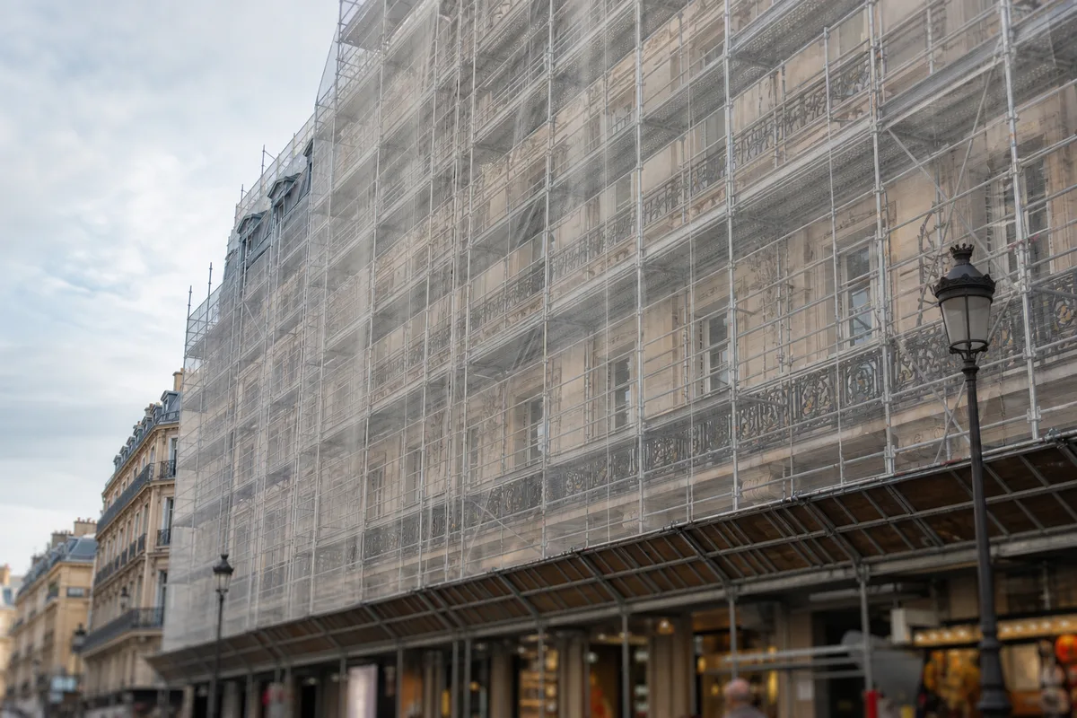 Façade d’immeuble ancien en pierre avec échafaudage de rénovation en centre-ville français