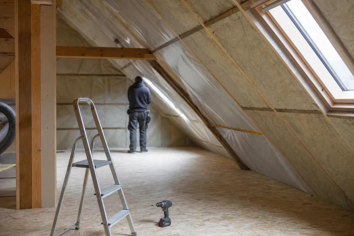 Combles en cours d&rsquo;aménagement avec rampants isolés et fenêtre de toit